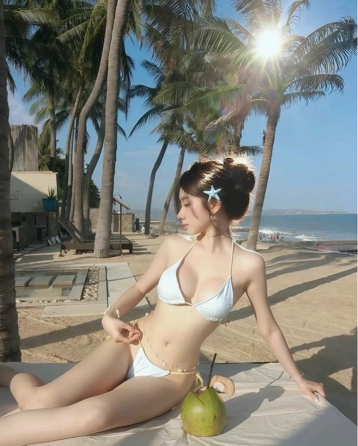 Cô gái xinh đẹp với bikini hai mảnh trên bãi biển