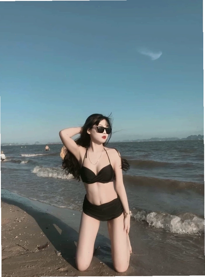 Cô gái xinh diện bikini màu sắc rực rỡ trên bãi biển, tạo dáng trẻ trung