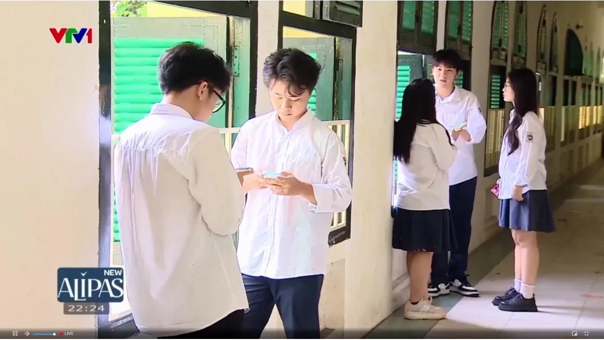 Học sinh chăm chú vào điện thoại thay vì sách vở